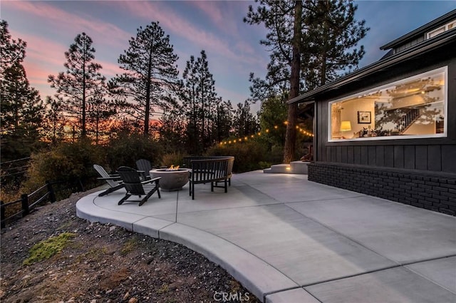 patio terrace at dusk featuring an outdoor fire pit