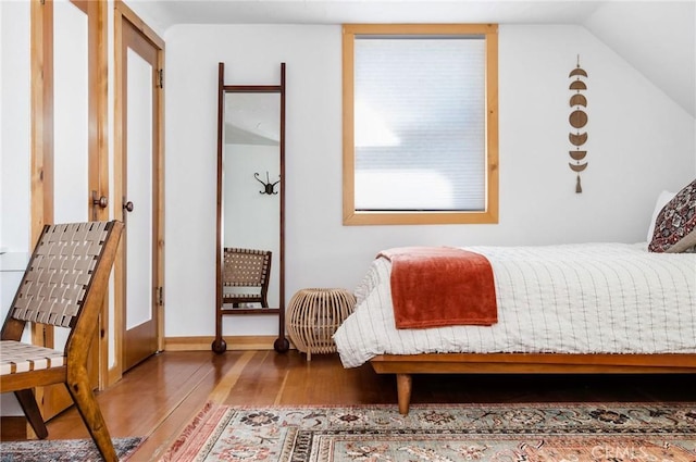 bedroom featuring hardwood / wood-style flooring and lofted ceiling