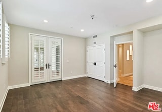 spare room with dark hardwood / wood-style floors and french doors