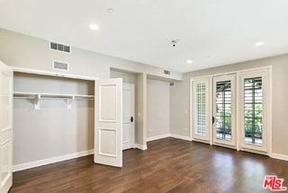 unfurnished bedroom with access to exterior and dark hardwood / wood-style floors