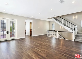 unfurnished living room featuring dark wood-type flooring and french doors