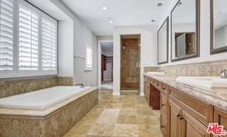 bathroom with vanity and independent shower and bath