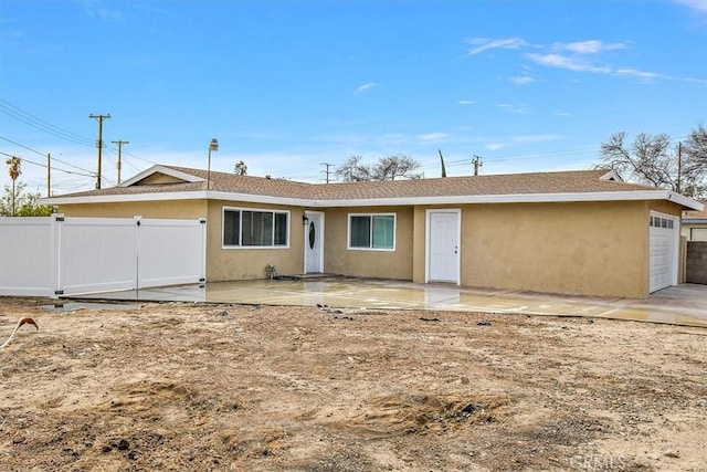 rear view of property with a patio area and a garage