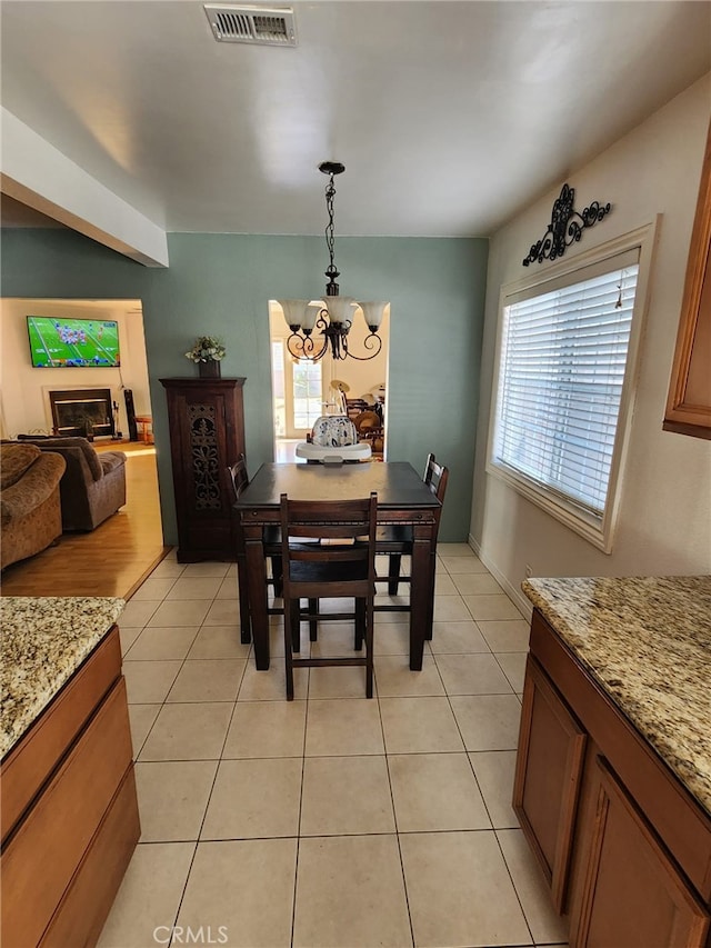 tiled dining space with an inviting chandelier