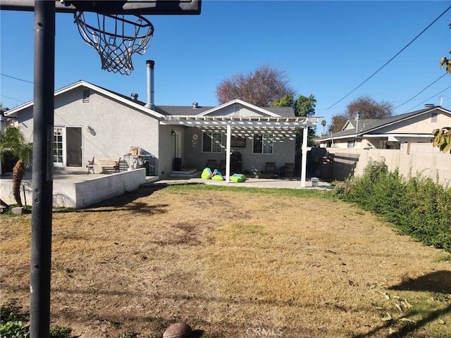 back of property featuring a pergola, a patio area, and a lawn