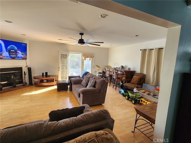 living room with ceiling fan and light wood-type flooring