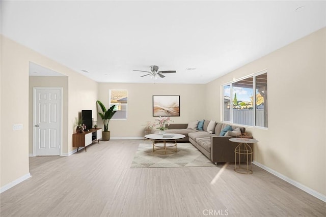 living room with light hardwood / wood-style flooring and ceiling fan