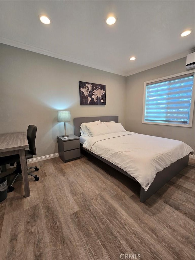 bedroom featuring a wall mounted AC, crown molding, and wood-type flooring