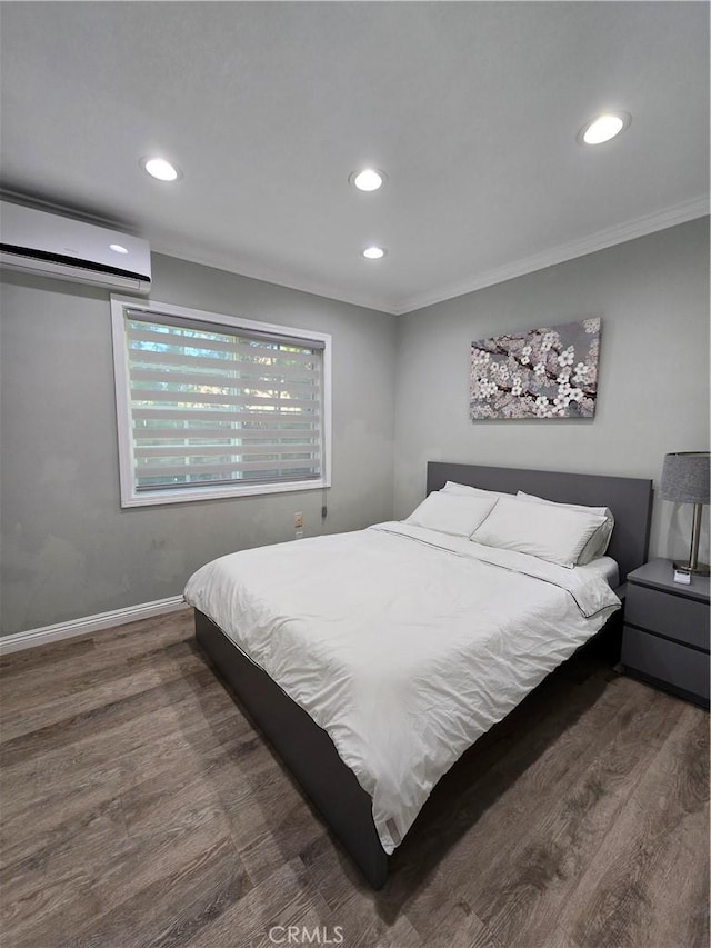 bedroom with an AC wall unit, crown molding, and dark hardwood / wood-style floors