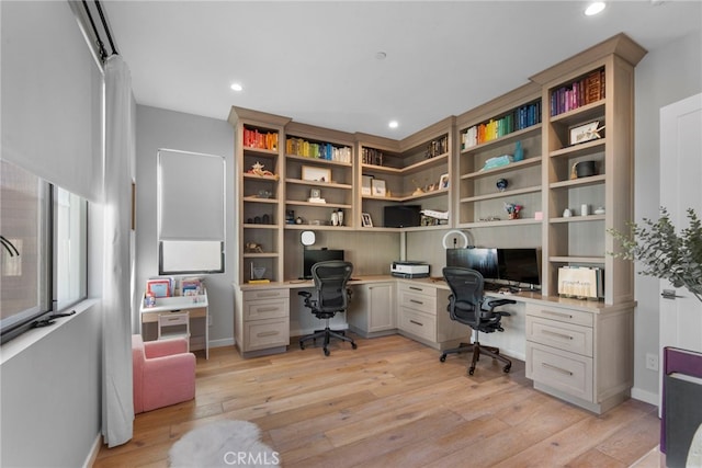 office featuring light hardwood / wood-style flooring and built in desk