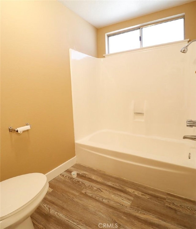 bathroom with a healthy amount of sunlight, toilet, shower / bath combination, and wood-type flooring