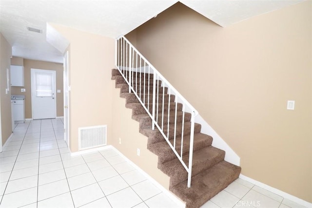 staircase featuring tile patterned flooring