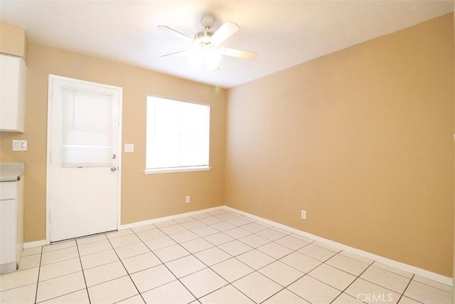 empty room featuring light tile patterned floors and ceiling fan