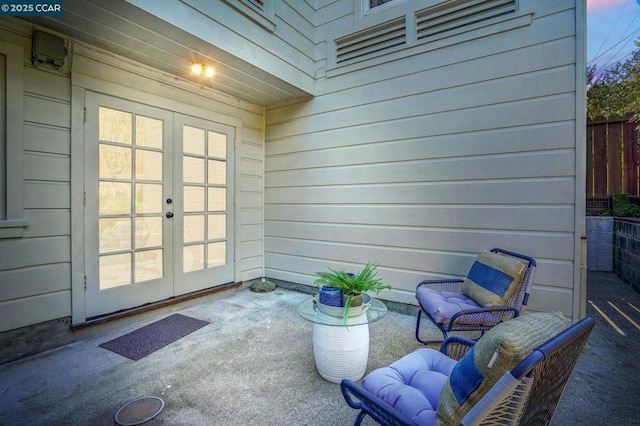 exterior space featuring french doors, wooden walls, and concrete floors