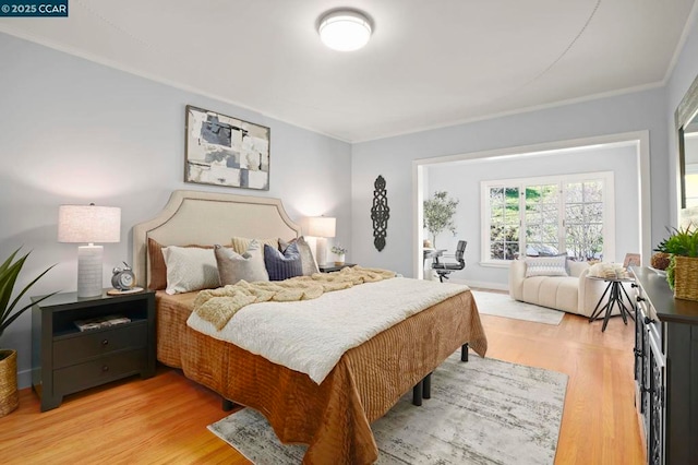 bedroom featuring crown molding and light hardwood / wood-style flooring