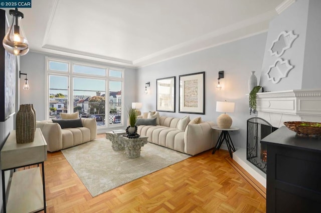 living room with crown molding, a tray ceiling, and light parquet flooring