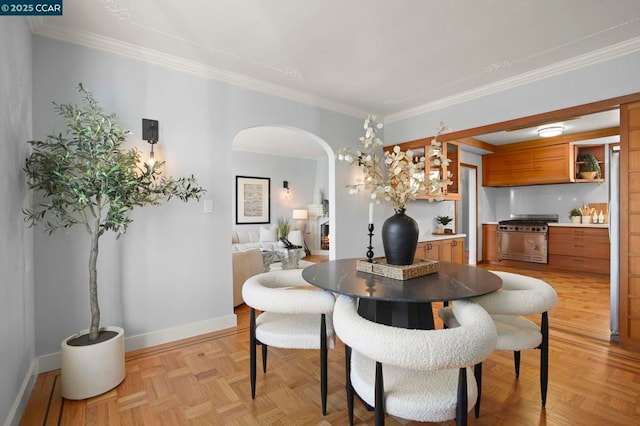 dining room featuring ornamental molding and light parquet flooring