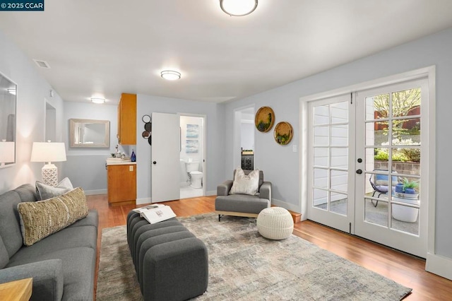 living room with french doors and light hardwood / wood-style flooring