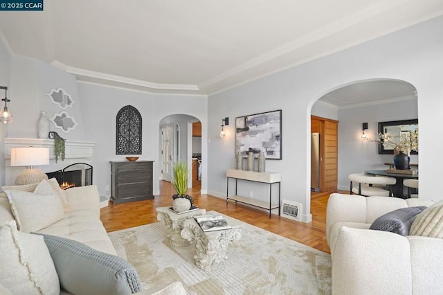 living room with ornamental molding and light parquet flooring