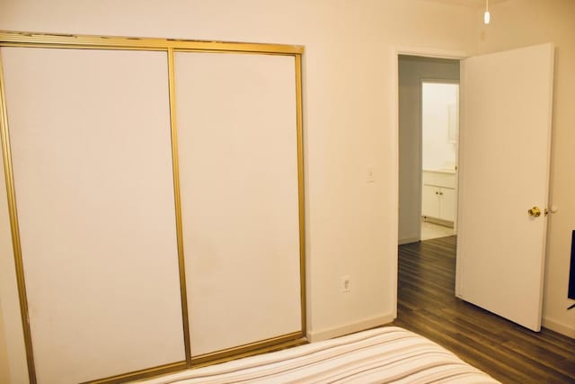 unfurnished bedroom featuring dark wood-type flooring and a closet