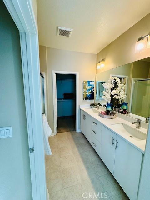 bathroom featuring walk in shower and vanity