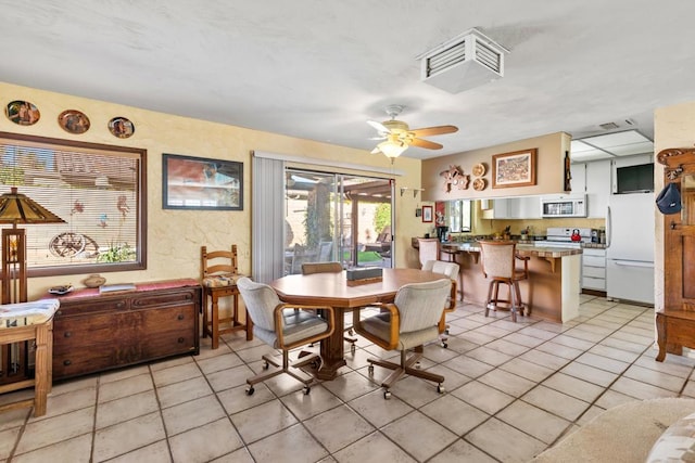 tiled dining area featuring ceiling fan