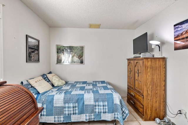 tiled bedroom with a textured ceiling