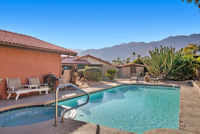 view of pool featuring a mountain view and a hot tub