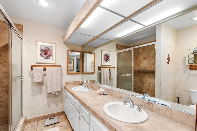 bathroom featuring tile patterned floors, toilet, a shower with door, and vanity