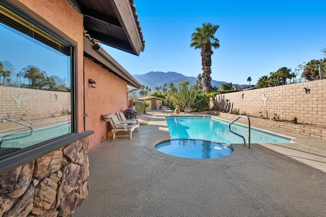 view of swimming pool with a mountain view and a patio area