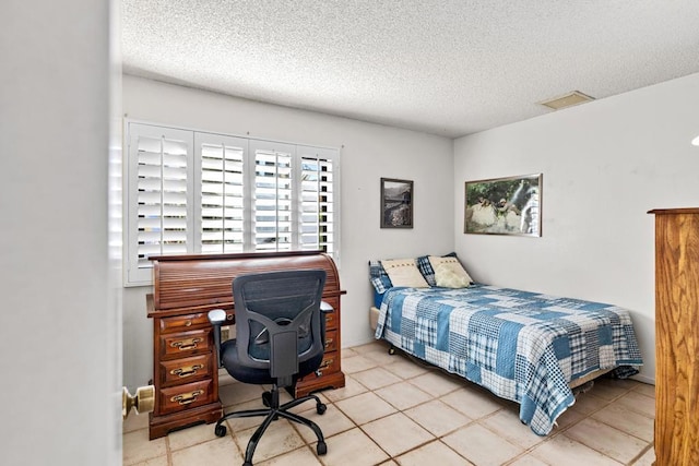 bedroom featuring a textured ceiling and light tile patterned floors