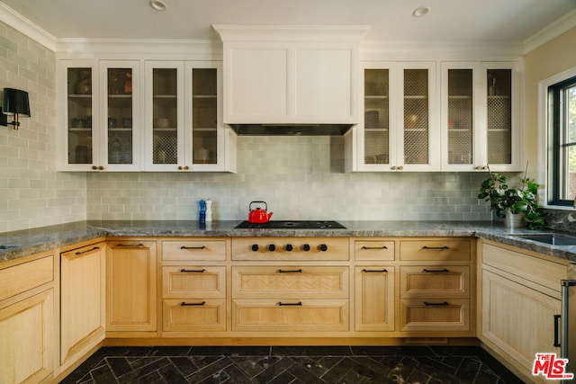 kitchen with range hood, light brown cabinets, and backsplash