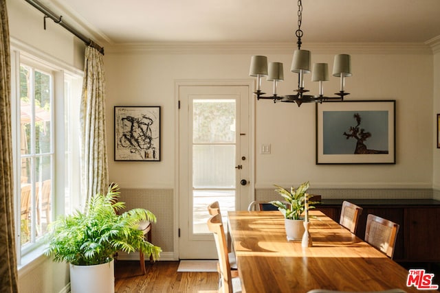 dining space featuring hardwood / wood-style flooring, ornamental molding, and a chandelier