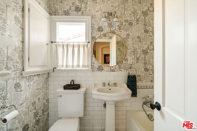 bathroom with a washtub and toilet