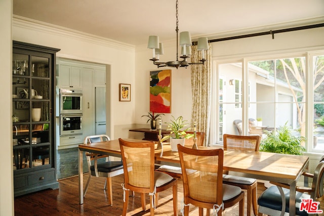 dining space featuring dark hardwood / wood-style flooring, ornamental molding, and a chandelier