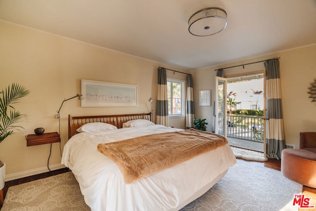 bedroom with ornamental molding and access to exterior