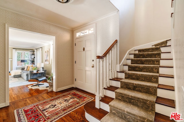 foyer entrance featuring dark hardwood / wood-style flooring and ornamental molding