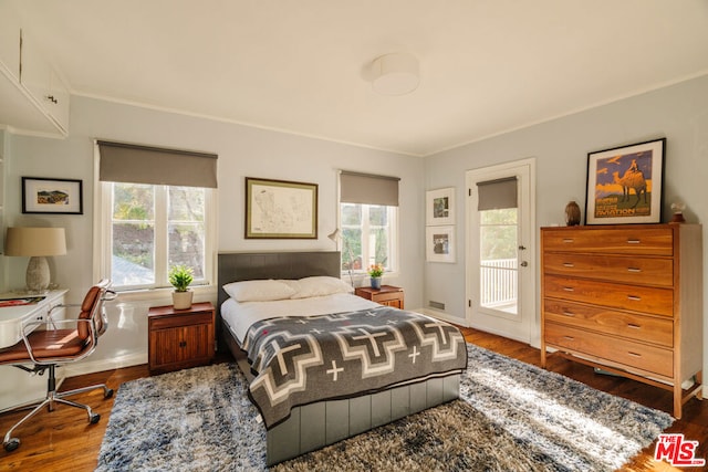 bedroom with hardwood / wood-style flooring, access to outside, and ornamental molding