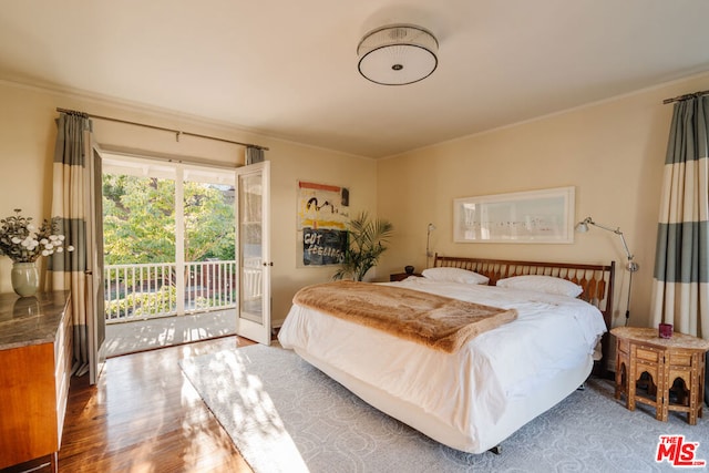 bedroom with crown molding, hardwood / wood-style floors, and access to outside