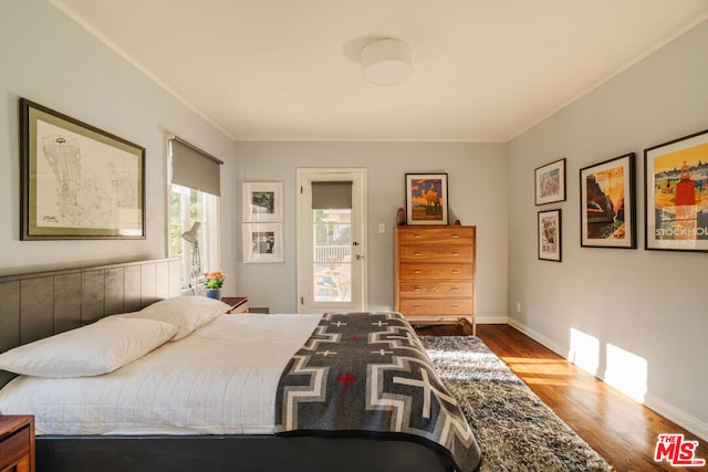 bedroom with ornamental molding and hardwood / wood-style floors