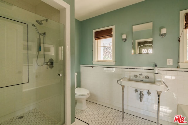 bathroom with tile walls, tile patterned flooring, and walk in shower