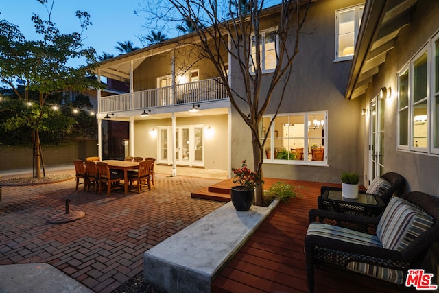 patio terrace at dusk with french doors and a balcony