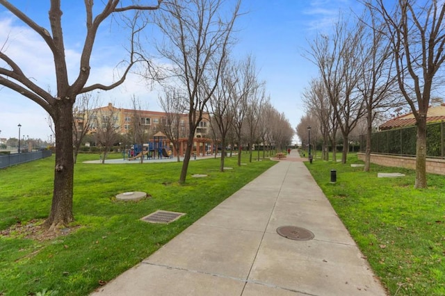 view of home's community featuring a playground and a lawn