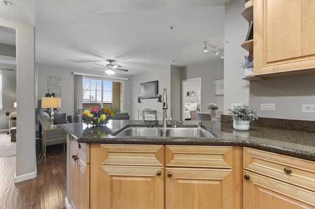 kitchen with sink, dark wood-type flooring, light brown cabinetry, and dark stone counters