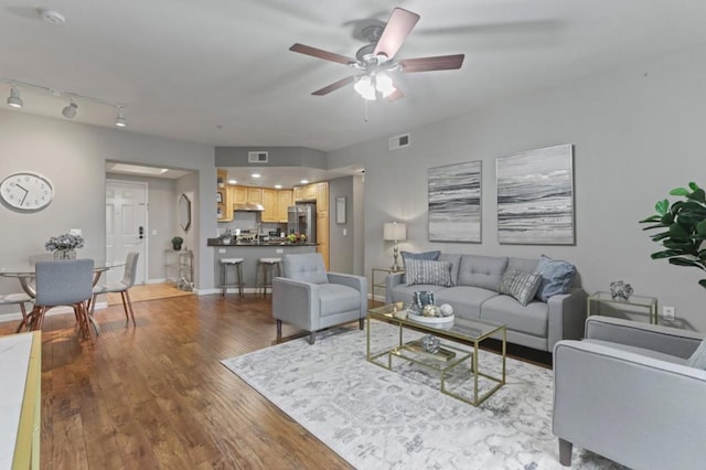 living room featuring hardwood / wood-style flooring and ceiling fan