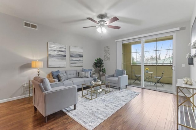 living room with ceiling fan and dark hardwood / wood-style flooring