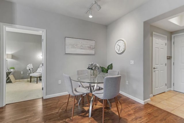 dining room featuring rail lighting and hardwood / wood-style floors