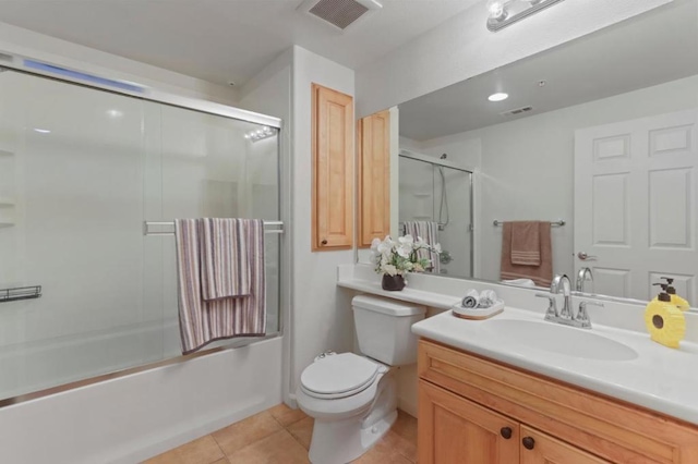 full bathroom featuring vanity, tile patterned floors, shower / bath combination with glass door, and toilet