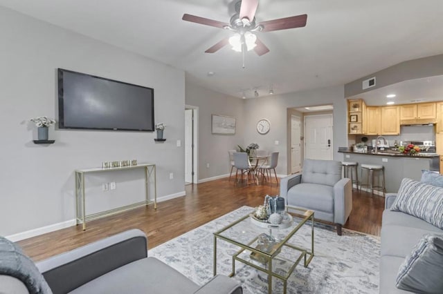 living room with hardwood / wood-style floors, sink, and ceiling fan