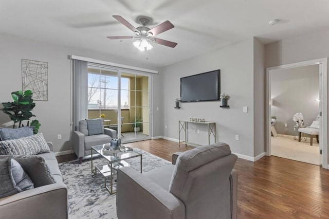 living room featuring ceiling fan and dark hardwood / wood-style flooring